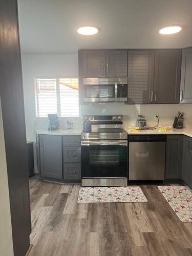a kitchen with stainless steel appliances and wooden cabinets at Boca Jewels with Heated Jacuzzi in Boca Raton