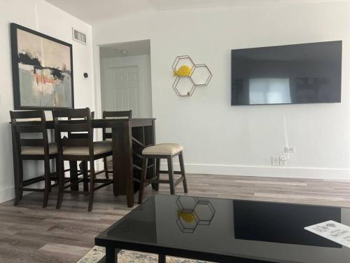 a living room with a table and chairs and a tv at Boca Jewels with Heated Jacuzzi in Boca Raton
