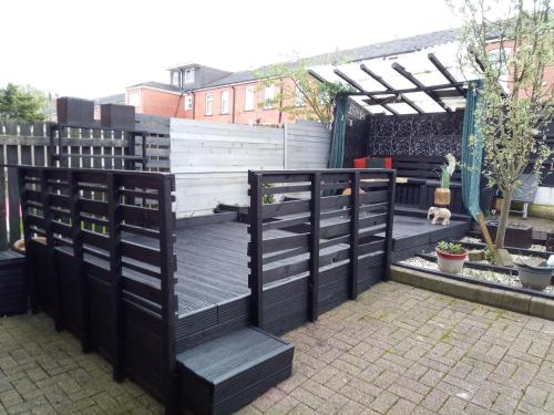 a garden with a black and white fence at 2 Bed House - Sleeps 4 - Pets - Garden - Parking in Bolton