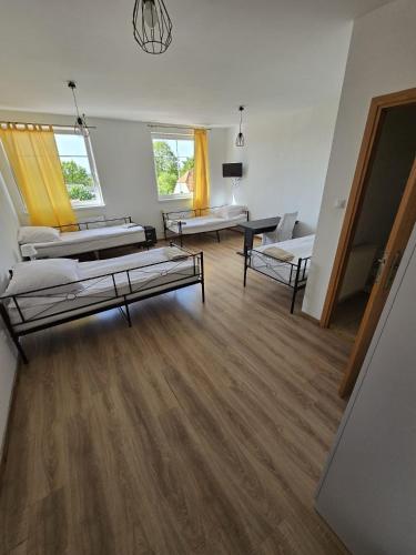 uma sala de estar com duas camas e um sofá em Średzka Korona em Sroda Slaska