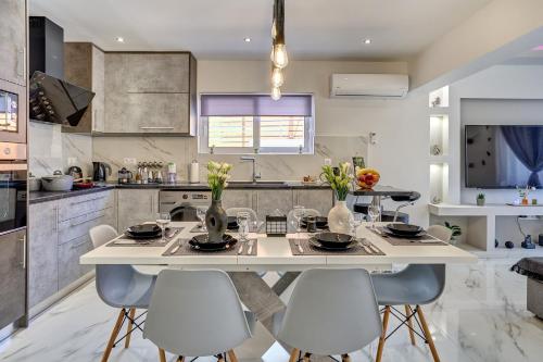 a kitchen with a large white table and chairs at Sea & Joy House in Ialyssos