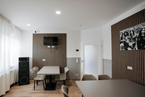 Una habitación con una mesa y sillas y un televisor. en HoltRock, en Oberhausen
