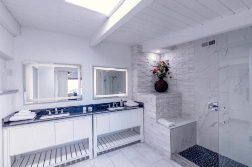 een witte badkamer met een wastafel en een douche bij Panoramic Ocean View Cottage Unit #4 in San Clemente
