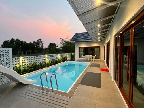 a swimming pool in the backyard of a house at บ้านพูลวิลล่าอุดรธานี by บ้านแสนรัก in Udon Thani