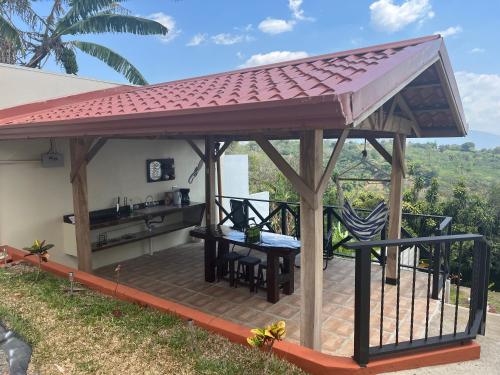 a gazebo with a table on a patio at Burios House in Alajuela