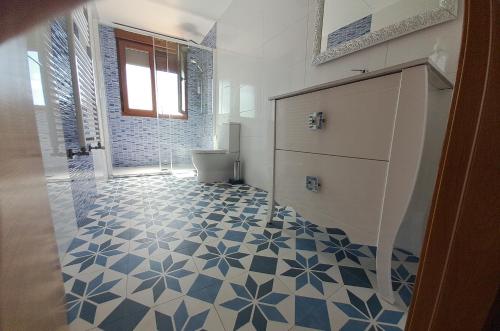 ein Badezimmer mit einem blauen und weißen Fliesenboden in der Unterkunft Apartamento Casa A Braña in O Grove