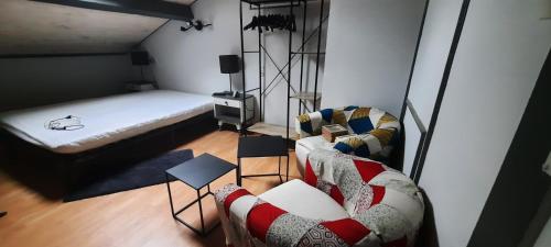 Cette petite chambre comprend un lit et un canapé. dans l'établissement Bienvenue chez vous, au Puy-en-Velay