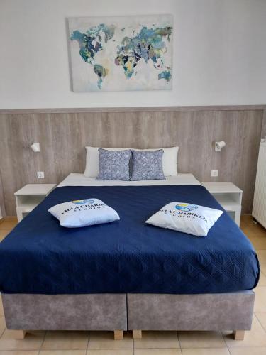 una camera con un letto blu con due cuscini sopra di Villa Chariklia Studios a Kambiá