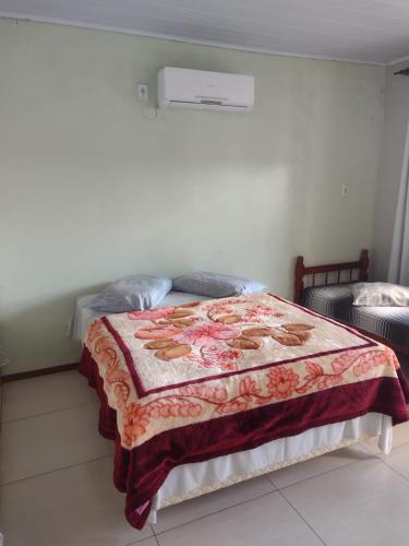 a bedroom with a bed with a blanket on it at Hotel dos viajantes in São Gabriel