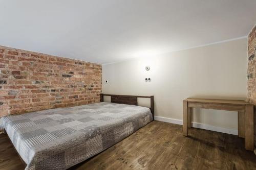 - une chambre avec un lit et un mur en briques dans l'établissement City Center Loft2 Apartment, à Tallinn