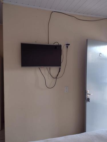 a flat screen tv on the wall of a bedroom at Hotel dos viajantes in São Gabriel