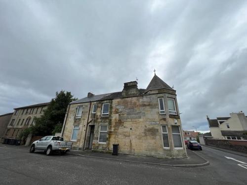 an old brick building on the side of a street at Perfect Ardrossan 1-bed flat. 5 min to north beach. in Ardrossan