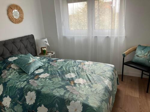 a bedroom with a bed and a window and a chair at Apartman Vita in Bjelovar