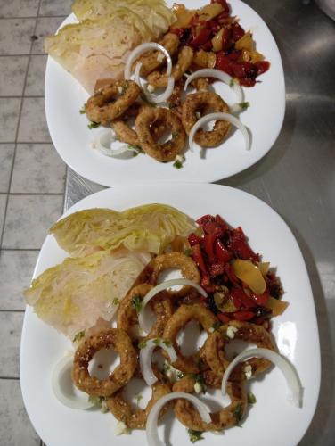 two plates of food with onion rings and lettuce at Marko Konak in Niš