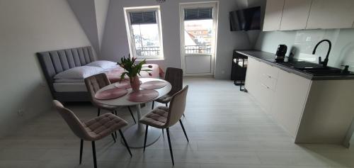 Apartamenty Łeba في ليبا: مطبخ مع طاولة وكراسي في غرفة