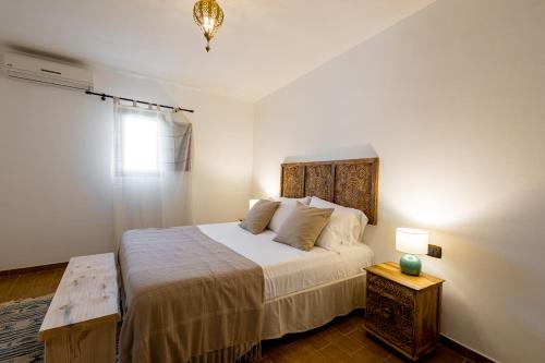 una camera da letto con un letto grande con testiera in legno di Sciaraqa a Mazara del Vallo