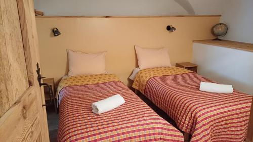two beds sitting next to each other in a room at Maison à Tour Briançon in Briançon