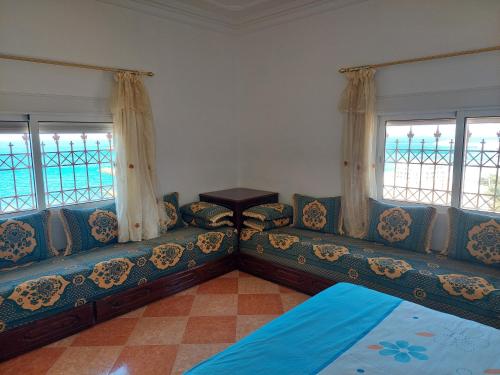 un divano in soggiorno con finestre di Vintage Palace a Ksar es-Seghir