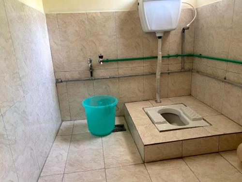 a bathroom with a bucket and a toilet in the floor at Moon Light Guest House Khaplu in Khaplu