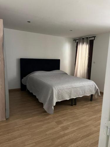 ein Schlafzimmer mit einem Bett in einem weißen Zimmer in der Unterkunft BAS DE VILLA AU SOLEIL in Mouans-Sartoux