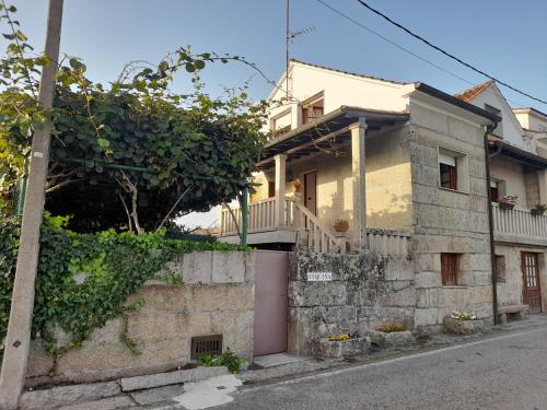 a yellow house with a balcony on a street at La Casita in Nogueira de Ramuin