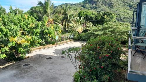 a garden with trees and bushes and a road at ISLA HOLIDAY HOME in Anse Royale