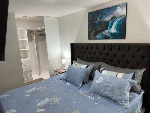 リマにある595 Departamento en Chorrillosのベッドルーム1室(青い掛け布団、枕付)