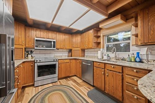 a kitchen with wooden cabinets and a large window at 5 Acres! Modern Cabin w/ Pikes Peak View in Florissant