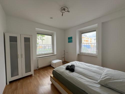 a bedroom with a bed and two windows at 32m2 - gemütliche Wohnung in zentraler Lage in Hagen