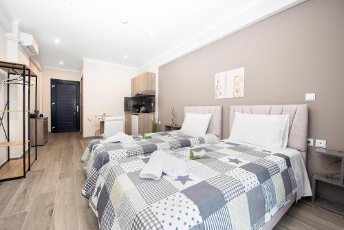two beds in a room with a kitchen at Oasis Apartments in Kalliópi