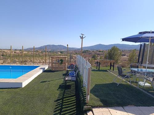 a backyard with a pool and a table and an umbrella at Casa Rural Natur Libre in Alicante