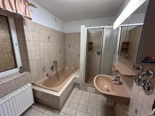 y baño con bañera, lavamanos y ducha. en Othman Appartements Alte Schmiede 2 OG L en Hannover