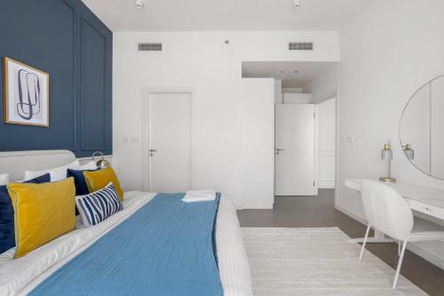 Schlafzimmer mit einem Bett mit gelben und blauen Kissen in der Unterkunft Silkhaus Luxurious 1BDR with Beach Access and City View in Abu Dhabi