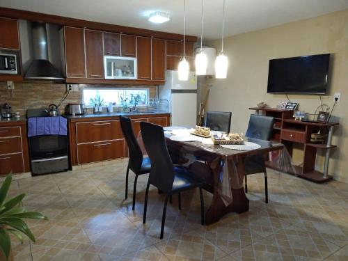 cocina con mesa y sillas en una habitación en Casa con piscina de uso exclusivo en Gualeguaychú