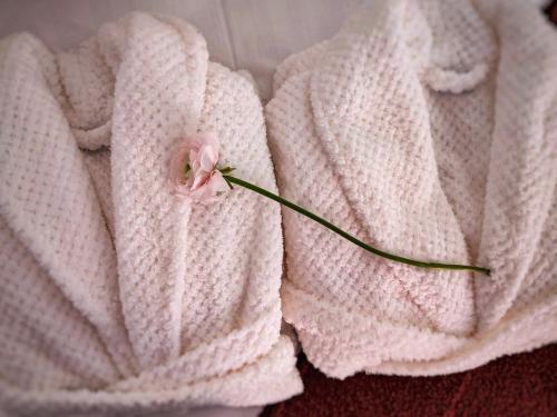 un fiore rosa seduto sopra una coperta bianca di High Tide Apartment a Zara (Zadar)
