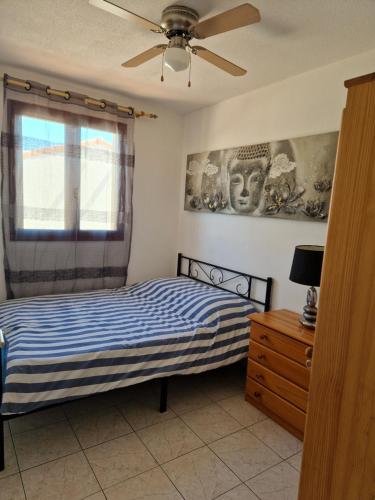 1 dormitorio con 1 cama y ventilador de techo en Villa 6p piscine spa privatif wifi proche des plages, en Le Barcarès