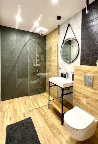 a bathroom with a toilet and a sink and a shower at Piękny Apartament Blisko Morza - Sarbinowo in Sarbinowo