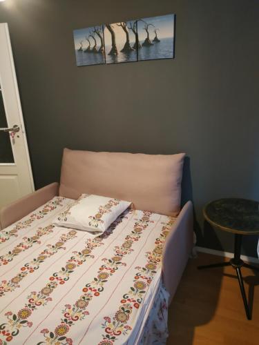 a bed in a room with a bedspread and a table at FEIDUM quarters rooms in Trzebinia