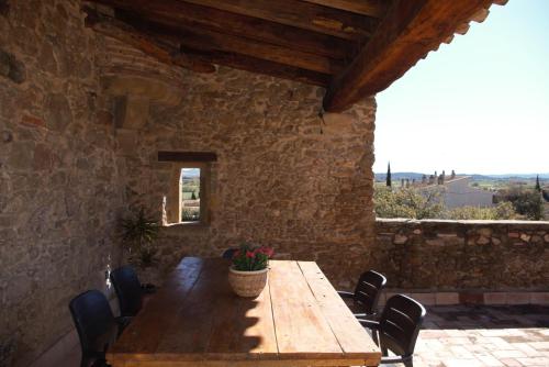 einen Holztisch in einem Zimmer mit einer Steinmauer in der Unterkunft Mas Solés in Parlavà