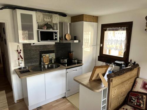une petite cuisine avec un évier et un micro-ondes dans l'établissement Résidence Le Royal - Charmant T3 dans le centre de Combloux MAE-2721, à Combloux