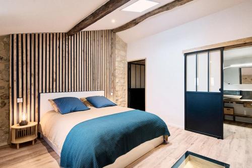 een slaapkamer met een groot bed met blauwe kussens bij Gîte au cœur des vignes in Montagne