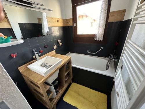 une salle de bain avec une baignoire et un lavabo et une baignoire dans l'établissement Résidence Le Royal - Charmant T3 dans le centre de Combloux MAE-2721, à Combloux