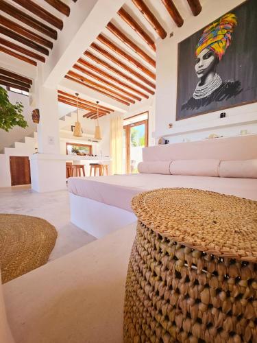 a bedroom with two beds and a large painting on the wall at Mfumbwi Twins Villa in Jambiani