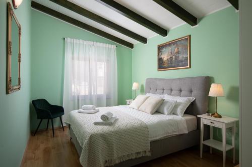um quarto com uma cama, uma cadeira e uma janela em Modern stone house with flowers & playground em Medulin