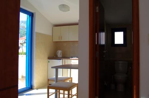 a small kitchen with a table and a toilet at Glory Suites in Budva