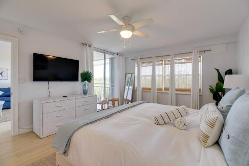 a white bedroom with a large bed and a flat screen tv at La Brisa Unit 105 North Building in Key West