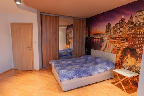 een slaapkamer met een bed en een schilderij aan de muur bij Grand Central Apartment in Skopje