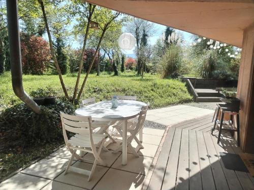 a table and chairs sitting on a patio at Le Nid du Chat Noir - Gîte La Maison Alvéole in Sciez