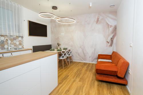 a kitchen with an orange chair and a table at Bubbly Apartment in Bled