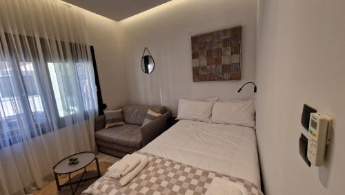 een kleine slaapkamer met een bed en een stoel bij MELIGEO APARTMENTS CENTER of IOANNINA in Ioannina
